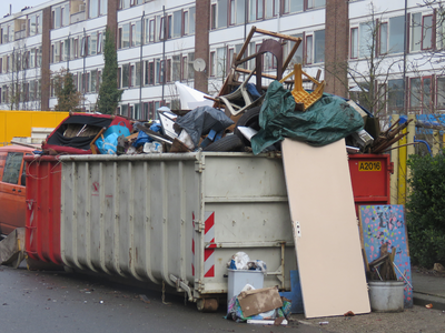829307 Afbeelding van een container boordevol overbodige huisraad in de Auriollaan in de wijk Kanaleneiland te Utrecht, ...